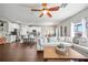 Open-concept living room featuring hardwood floors and plenty of natural light from multiple windows at 2829 Maple Brook Loop, Lutz, FL 33558