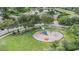 Aerial view of a colorful community playground with slides, climbing structures, and mature trees in a neighborhood at 2829 Maple Brook Loop, Lutz, FL 33558