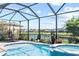 Screened in pool and spa overlooking a tranquil lake view, with patio furniture for outdoor relaxation at 2829 Maple Brook Loop, Lutz, FL 33558