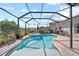 A kidney-shaped pool and spa are surrounded by a screened enclosure and patio at 2829 Maple Brook Loop, Lutz, FL 33558