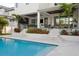 Elegant outdoor living space featuring a pool, covered patio, and lush landscaping for relaxation and entertainment at 2902 S Beach Dr, Tampa, FL 33629