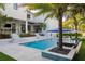 Stunning backyard featuring a large pool, spa, covered patio, and lush landscaping for ultimate relaxation at 2902 S Beach Dr, Tampa, FL 33629
