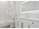 Bright bathroom features a floating vanity, lighted mirror, tub, and shower at 2902 S Beach Dr, Tampa, FL 33629