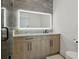 Bathroom boasts wood-look vanity with black hardware and a large illuminated mirror at 2902 S Beach Dr, Tampa, FL 33629