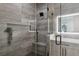 Modern bathroom features wood-look vanity, lighted mirror, and glass shower with gray-tone tile at 2902 S Beach Dr, Tampa, FL 33629