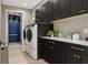 Modern laundry room featuring sleek cabinetry, a front-load washer and dryer, and an elevator at 2902 S Beach Dr, Tampa, FL 33629