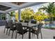 Outdoor dining with seating for eight, overlooking pool and lush landscaping at 2902 S Beach Dr, Tampa, FL 33629