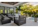 Outdoor lounge area with modern seating, a fire pit, and a view of the pool and tropical landscape at 2902 S Beach Dr, Tampa, FL 33629