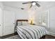 Bright bedroom featuring a striped quilt, dark hardwood floors, and a sun-filled window with white shutters at 301 81St Ne Ave, St Petersburg, FL 33702