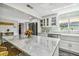 Bright kitchen features marble counters, white cabinetry, stainless appliances, and a farmhouse sink at 301 81St Ne Ave, St Petersburg, FL 33702