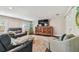 Cozy living room featuring a sectional couch, wooden entertainment center, and dark hardwood floors at 301 81St Ne Ave, St Petersburg, FL 33702