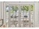 View from inside to relaxing patio with comfortable seating and white picket fence, framed by French doors at 301 81St Ne Ave, St Petersburg, FL 33702