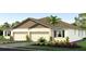 Beautiful, three-car garage home with stucco facade, manicured lawn and mature landscaping at 31450 Paper Birch St, Wesley Chapel, FL 33545