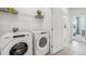 Modern laundry room equipped with high-efficiency washer and dryer, and ample storage on the wire shelf at 31450 Paper Birch St, Wesley Chapel, FL 33545