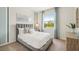 Bright bedroom featuring a comfortable bed with a gray headboard and a window with a view at 31458 Paper Birch St, Wesley Chapel, FL 33545