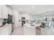 Open-concept kitchen with stainless steel appliances, white cabinetry, and center island connects to dining area and living room at 31458 Paper Birch St, Wesley Chapel, FL 33545