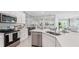 Modern kitchen featuring stainless steel appliances, stylish countertops, and an open layout with views to dining and living spaces at 31458 Paper Birch St, Wesley Chapel, FL 33545
