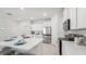 Modern kitchen with stainless steel appliances, sleek white cabinetry, and an island with counter seating and a sink at 31458 Paper Birch St, Wesley Chapel, FL 33545