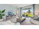Inviting living room with stylish furniture, light-blue accent wall, and sliding glass doors to the patio at 31458 Paper Birch St, Wesley Chapel, FL 33545