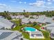 A serene aerial view shows a community with well-maintained houses and a pristine pool area surrounded by lush landscaping at 3520 51St W Ave, Bradenton, FL 34210