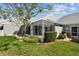 Exterior view of a screen enclosed patio overlooking a well-maintained backyard with lush landscaping at 3520 51St W Ave, Bradenton, FL 34210
