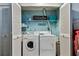 Functional laundry room with washer, dryer, shelving, and laundry themed decor at 3520 51St W Ave, Bradenton, FL 34210