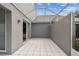 Tiled patio with overhead covering, sliding glass doors, and neutral gray exterior walls at 3520 51St W Ave, Bradenton, FL 34210