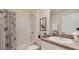 Well-lit bathroom featuring a shower-tub combo, granite counters, and a decorative mirror at 35695 Lockman Way, Zephyrhills, FL 33541