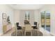 Cozy dining room with a modern round table, chandelier lighting, and a sliding door to the backyard at 35695 Lockman Way, Zephyrhills, FL 33541