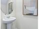 Elegant powder room features a stylish round mirror and decorative artwork, creating a sophisticated touch at 3633 Copper Beech Dr, Land O Lakes, FL 34638