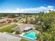 An aerial view showcasing a home with a pool, surrounded by green lawns and mature trees at 3900 38Th S St, St Petersburg, FL 33711