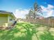 The backyard boasts a lush lawn, a wooden fence, and palm trees in the distance at 3900 38Th S St, St Petersburg, FL 33711