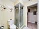 Bathroom featuring a glass shower, toilet, and unique sconce lighting at 3900 38Th S St, St Petersburg, FL 33711