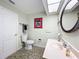 Bright bathroom with a round, decorative mirror, neutral wall color and tiled flooring at 3900 38Th S St, St Petersburg, FL 33711