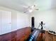 Spacious bedroom featuring dark wood floors, neutral walls, a ceiling fan, and exercise equipment at 3900 38Th S St, St Petersburg, FL 33711