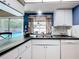 Kitchen featuring modern appliances, tiled floors, and a large window overlooking the pool area at 3900 38Th S St, St Petersburg, FL 33711