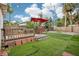 Enjoy the outdoors in this backyard with synthetic grass, a wood deck, and seating at 4406 W Harbor View Ave, Tampa, FL 33611