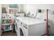 Bright laundry room featuring a newer white washer and dryer, shelving, and updated flooring at 4406 W Harbor View Ave, Tampa, FL 33611