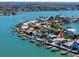 Aerial view showcases a waterfront home with a pool, boat dock, and surrounding tropical landscape at 474 20Th Ave, Indian Rocks Beach, FL 33785