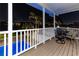 Night view from the balcony with table and chairs overlooking the pool and water at 474 20Th Ave, Indian Rocks Beach, FL 33785