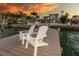 A waterfront dock with two white Adirondack chairs providing an inviting spot to enjoy the sunset at 474 20Th Ave, Indian Rocks Beach, FL 33785