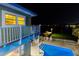 Night view of the exterior with illuminated pool area, balcony, and tranquil waterfront at 474 20Th Ave, Indian Rocks Beach, FL 33785