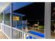 Night view of the exterior with illuminated pool area, balcony, and tranquil waterfront at 474 20Th Ave, Indian Rocks Beach, FL 33785