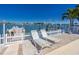 Relaxing lounge chairs on a waterfront patio, offering serene views of the tranquil bay waters at 474 20Th Ave, Indian Rocks Beach, FL 33785