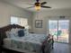 Waterfront main bedroom with a king bed, ceiling fan, and sliding glass door that leads to a patio at 474 20Th Ave, Indian Rocks Beach, FL 33785