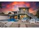 Backyard pool with white lounge furniture, and a two-story home with balconies at dusk at 474 20Th Ave, Indian Rocks Beach, FL 33785