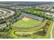 Aerial view of a baseball field and parking within a residential community surrounded by lush vegetation at 5009 Sandy Brook Cir, Wimauma, FL 33598