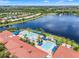 Panoramic aerial view of a residential community, highlighting a large lake with a fountain and a swimming pool at 5009 Sandy Brook Cir, Wimauma, FL 33598