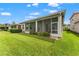 Green lawn is enhanced by screened lanai, plantings, and blue skies at 5009 Sandy Brook Cir, Wimauma, FL 33598