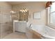 Bright bathroom boasts a soaking tub, tiled shower, and white vanity at 5009 Sandy Brook Cir, Wimauma, FL 33598